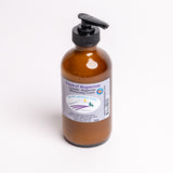 An amber glass pump bottle of Big Sky Lavender Farms Cream of Magnesium moisturizing cream, featuring a black pump dispenser and a white label with purple and blue text, set against a plain white background.