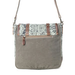 A gray canvas shoulder bag with a patterned flap in black and white, brown leather straps, and a front zippered pocket, shown against a plain white background.