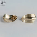 Two sterling silver earrings on a gray background 