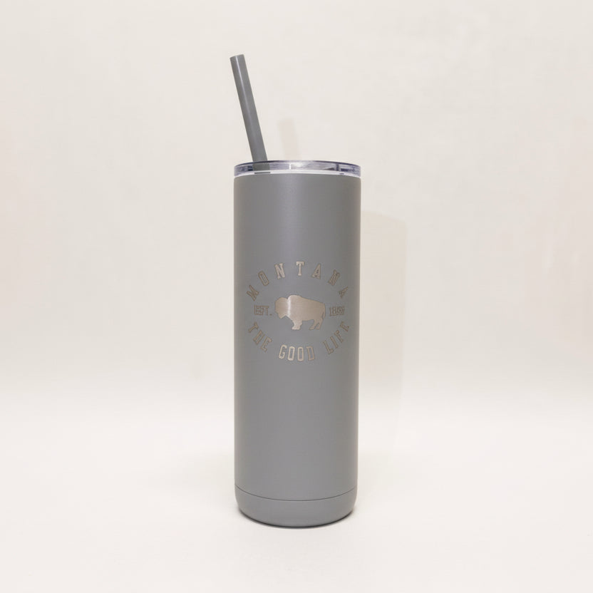White tumbler with 'Montana is the Good Life' text and a straw on a light beige background
