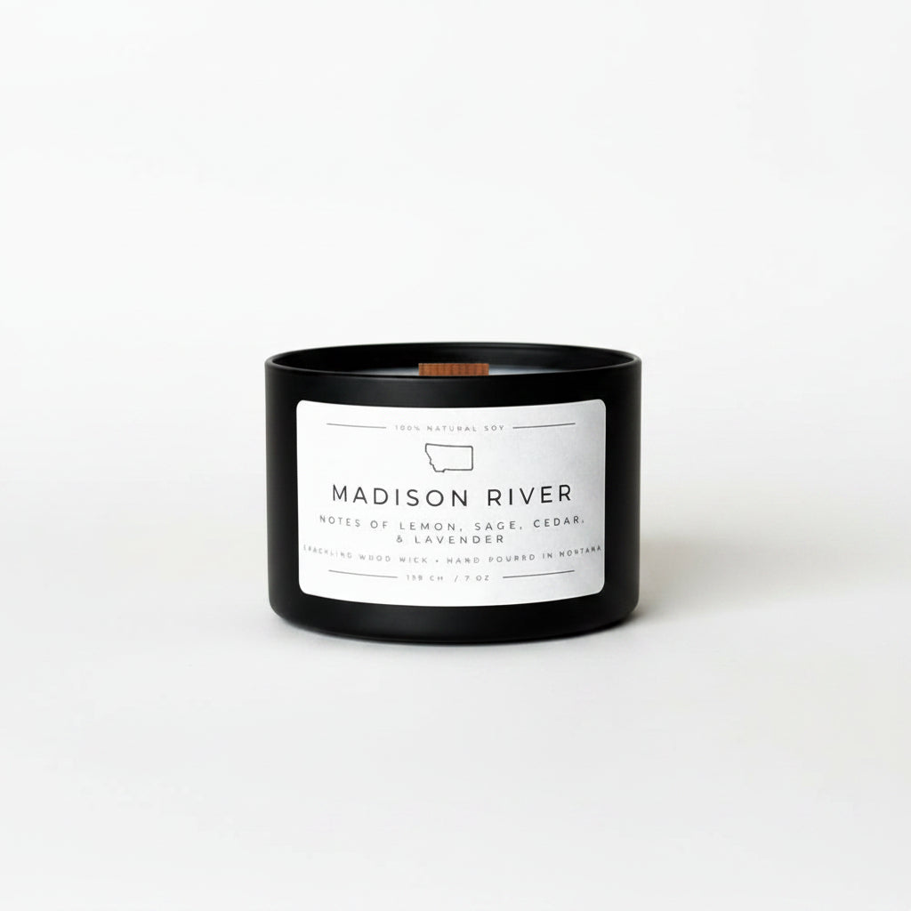 Black candle with a white label on a white surface and background