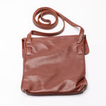 A brown leather crossbody bag with a matching shoulder strap, displayed on a clean white background.