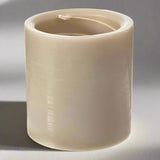 Beige cylindrical candle on a white background