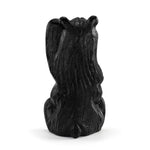 Black resin sculpture of a bear on a white background