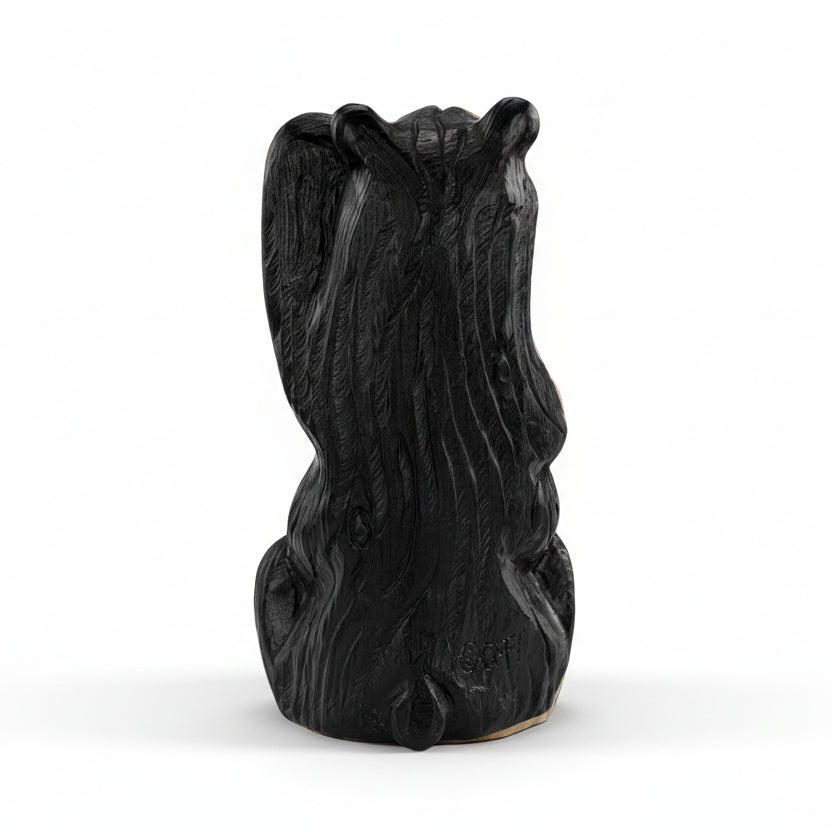 Black resin sculpture of a bear on a white background