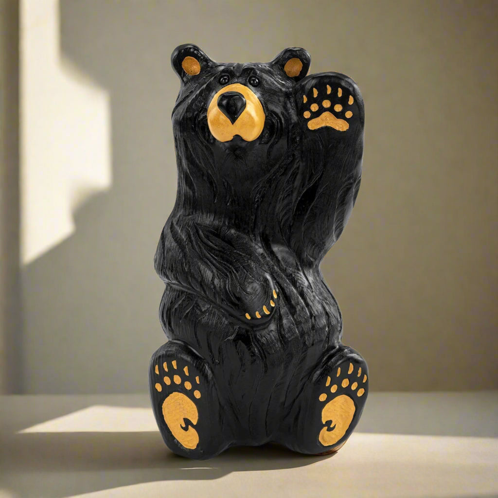 Black bear figurine with yellow accents on a white background