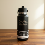 Black water bottle with 'Montana' branding on a wooden surface