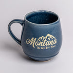 Blue mug with 'Montana The Last Best Place' text on a light gray background
