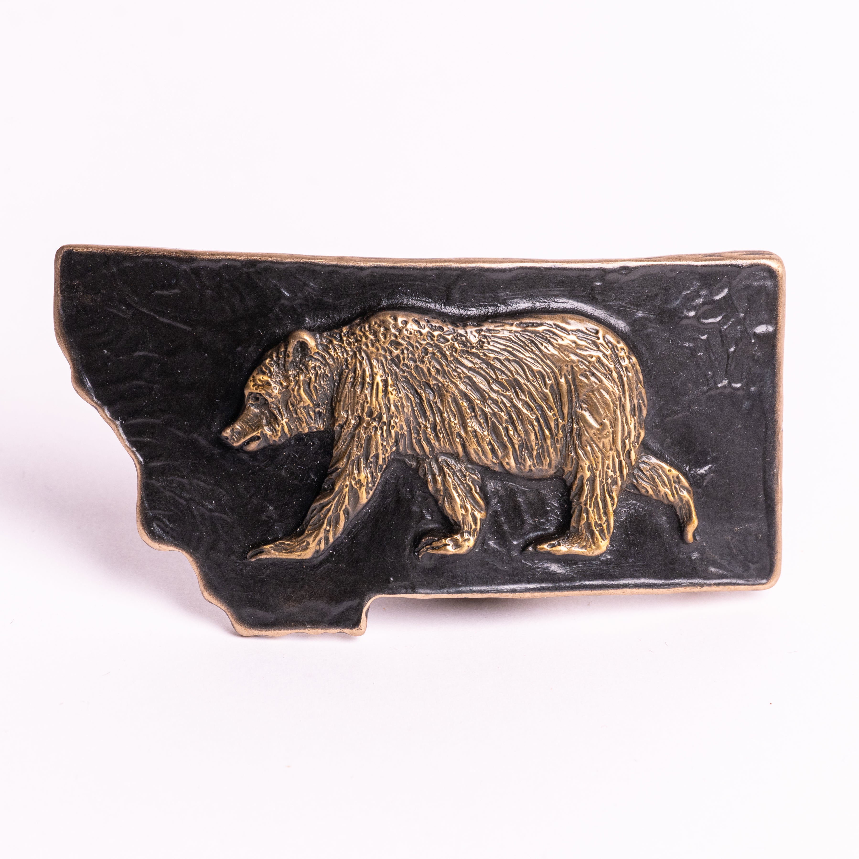 Metallic bear emblem belt buckle on a black background