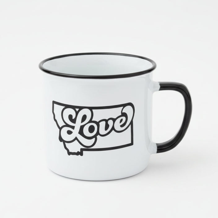 White mug with 'Love' and a state outline design on a wooden surface with a snowy background