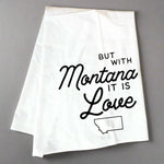 White towel with black text 'But with Montana it is Love' on a wooden surface