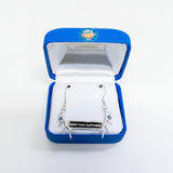 Silver earrings with Montana Sapphire in a blue jewelry box on a white background