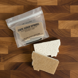 State scrub sponges on a wooden surface with packaging.