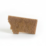 Brown natural sponge on a white surface with a blurred background