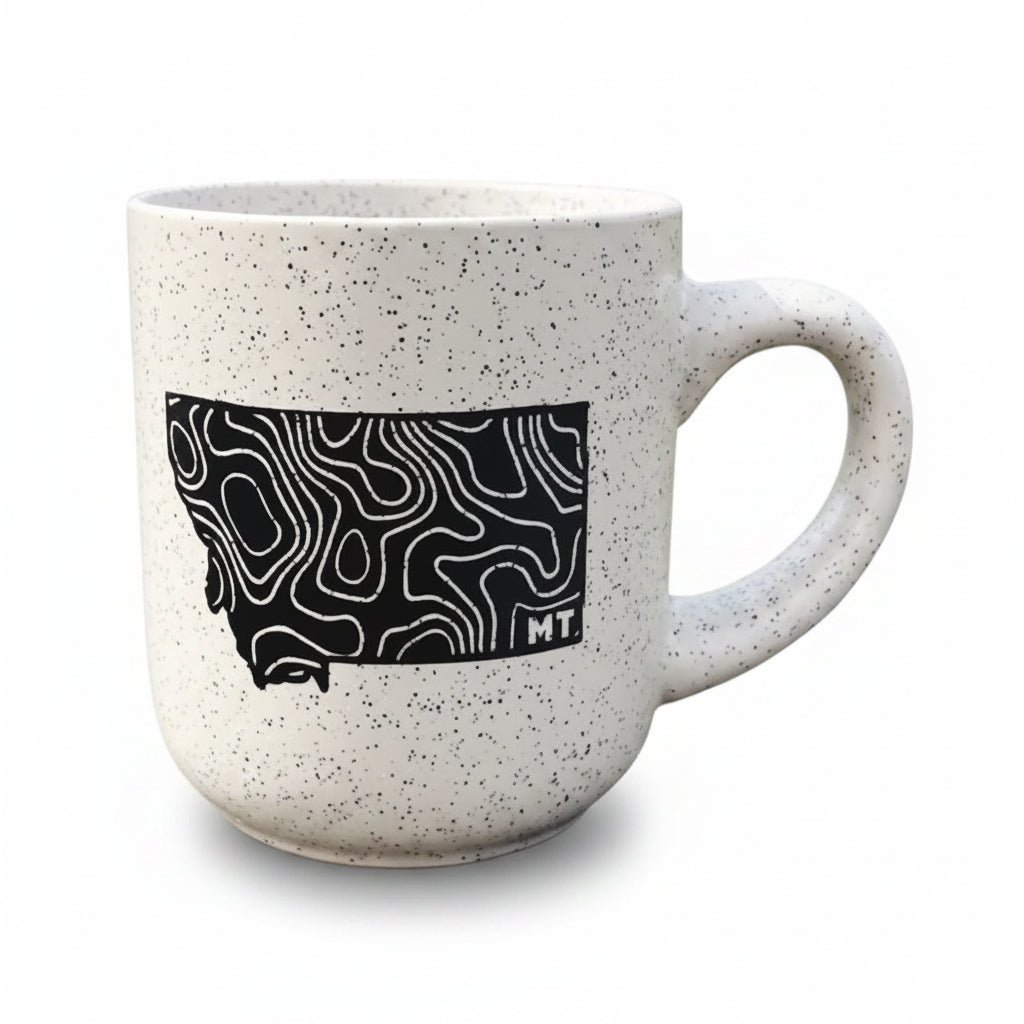 Speckled mug with black topographic design of Montana on a white background