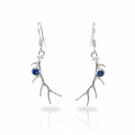 Silver branch-like earrings with blue gemstones on a white background