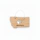 A small wooden ornament shaped like the state of Montana, hanging from a thin metal wire loop. The wood is light tan with a black bear paw print and the word "Montana" engraved on it.
