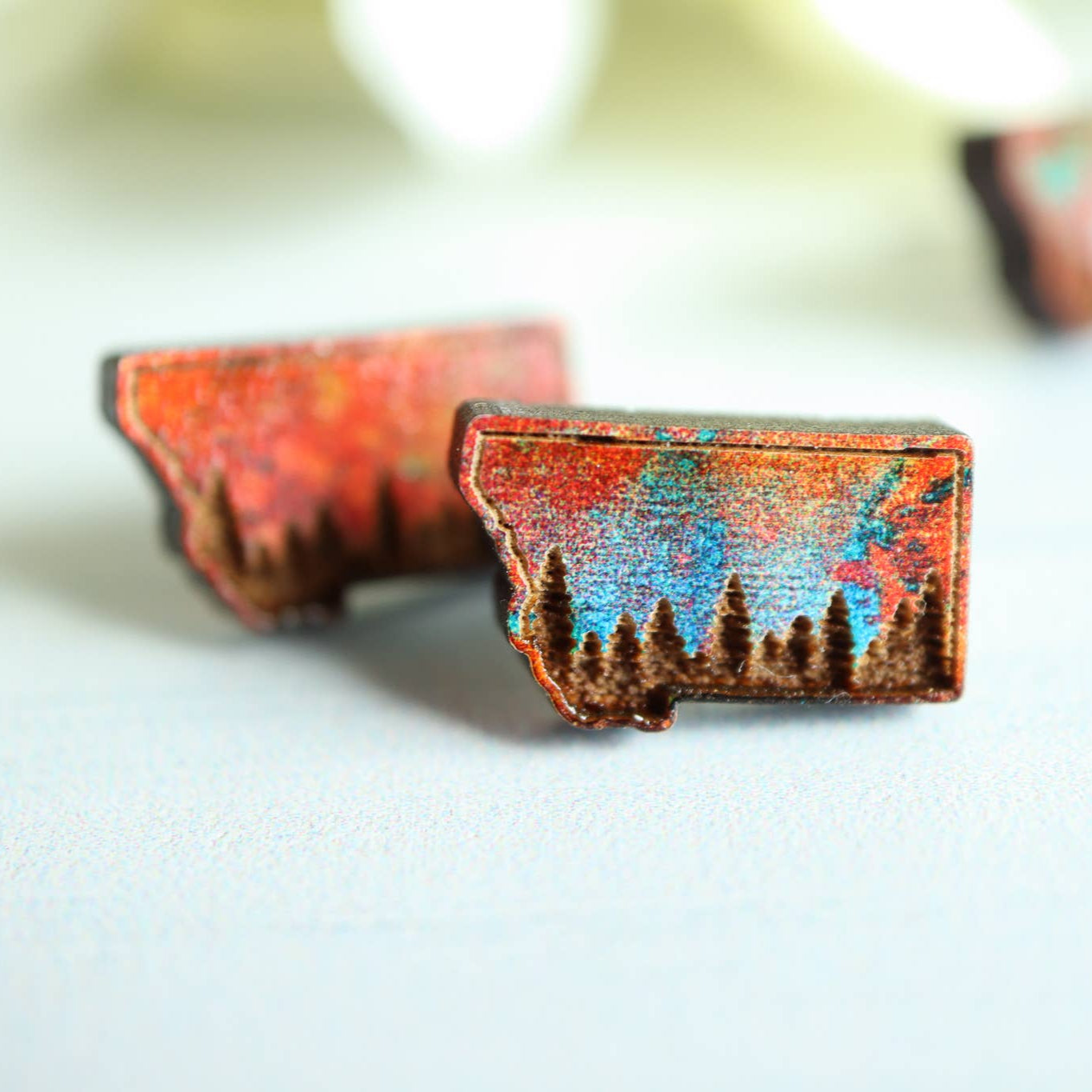 Wooden earrings with mountain and forest design on a white background