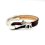 Bracelet with silver elk charm and brown leather strap on a white background