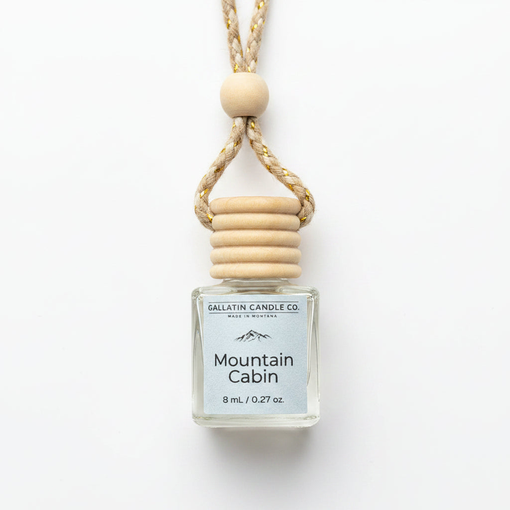 A small glass bottle reed diffuser with a white label reading 'Gallatin Candle Co. Mountain Cabin' and '8 mL / 0.