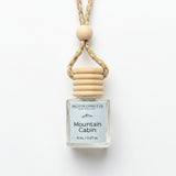 A small glass bottle reed diffuser with a white label reading 'Gallatin Candle Co. Mountain Cabin' and '8 mL / 0.