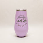 Purple tumbler with mountain design and text on a light gray background