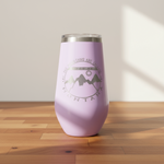 Pink tumbler with mountain design on a wooden surface