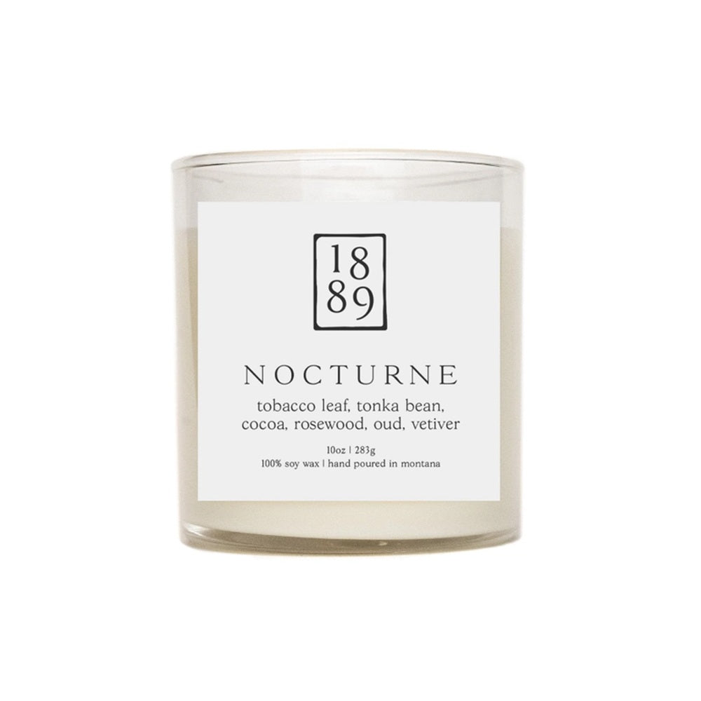 Candle labeled '1889 Nocturne' with a white label on a white background