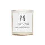 Candle labeled '1889 Nocturne' with a white label on a white background