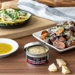 Table setting with plates of food, a container of Parmesan & Asiago seasoning, and bread.