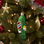 Decorative pickle ornament with a pickleball paddle design on a Christmas tree.