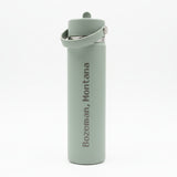 Gray water bottle with 'Bozeman, Montana' text on a wooden surface.