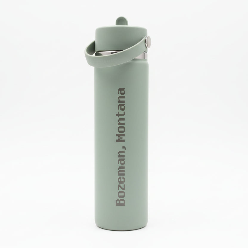 Gray water bottle with 'Bozeman, Montana' text on a wooden surface.