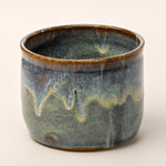 Ceramic pot with a textured glaze on a white background