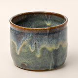 Ceramic pot with a textured glaze on a white background