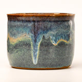 Ceramic pot with blue and brown glaze on a white background