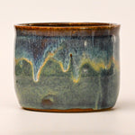 Ceramic pot with blue and brown glaze on a white background