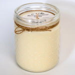 Jar candle with twine wrapping on a white background