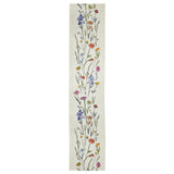 A long, narrow cream-colored runner rug featuring a vertical botanical pattern of wildflowers in blue, purple, pink, orange, and yellow on a white background.