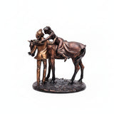 A bronze-finished sculpture of a cowboy and cowgirl riding a horse, mounted on a textured round base, shown against a plain white background.