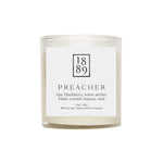 Candle with a label featuring the number 1889 and product description on a white background