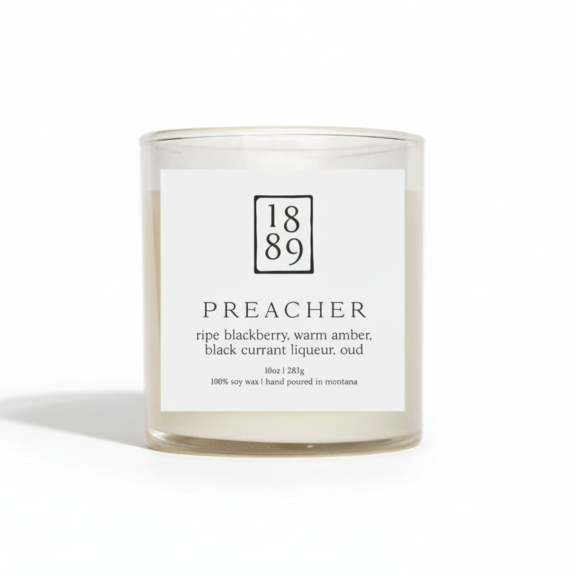 Candle with a label featuring the number 1889 and product description on a white background