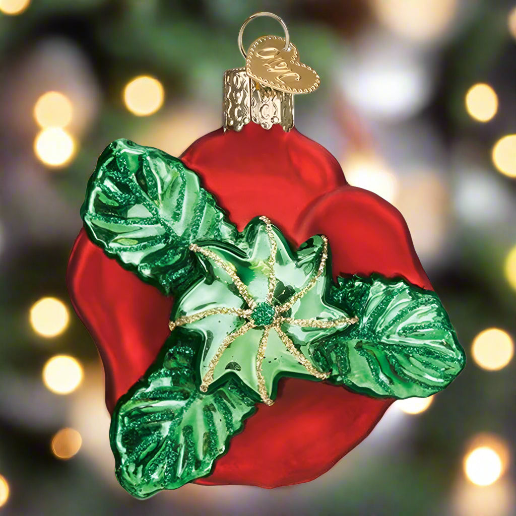 Decorative Christmas ornament with red base and green leaves on a white background