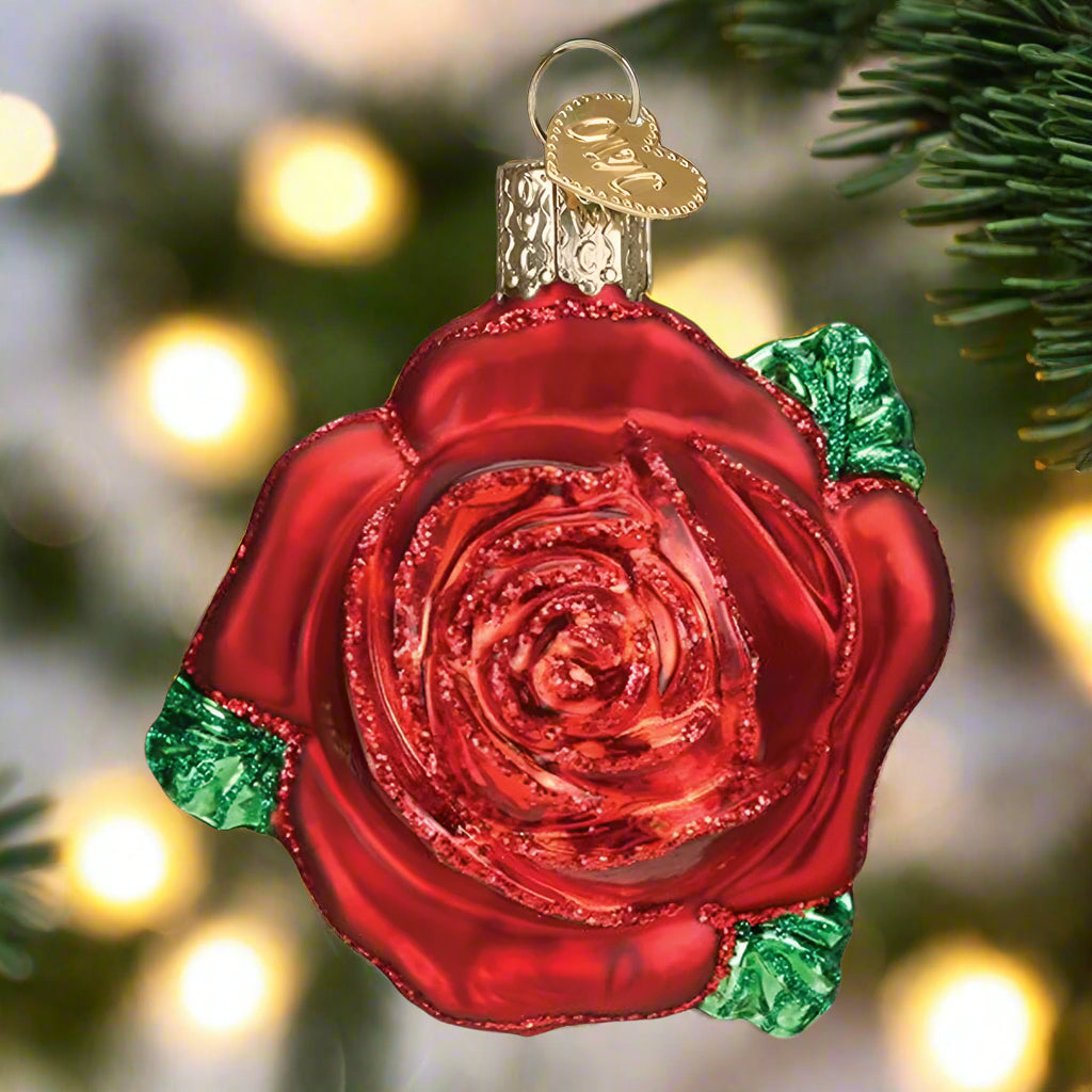 Red rose-shaped ornament with green accents on a white background