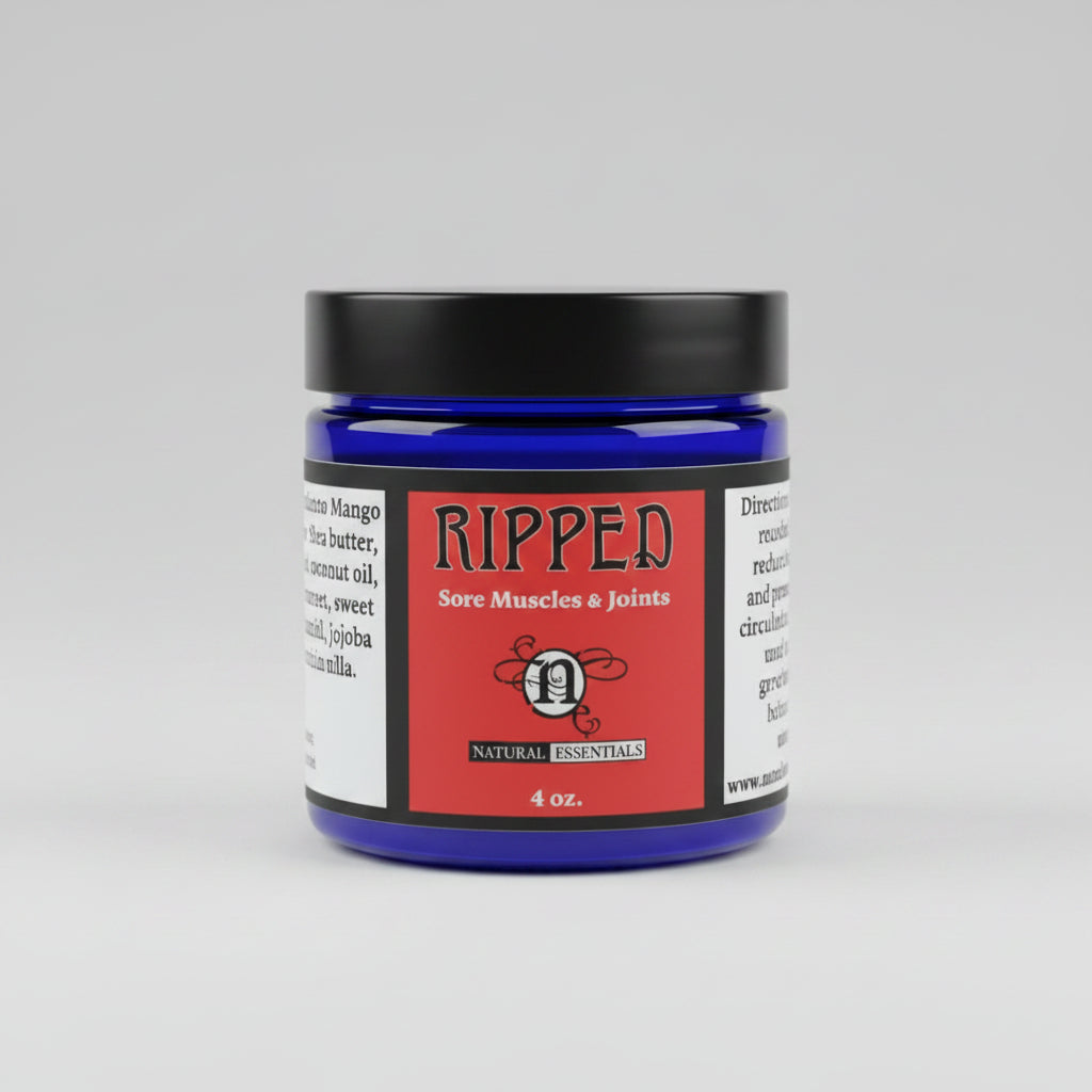A jar of Natural Encouragement 'Ripped' sore muscles and joints cream, featuring a dark blue jar, black lid, and red label, set on a rustic wooden surface.