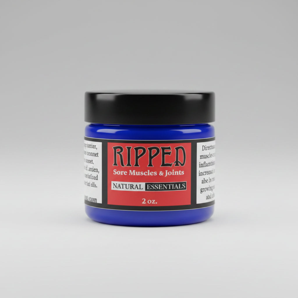 A small jar of Ripped Sores, Muscles & Joints Natural Essentials cream sits on a rustic, weathered wooden surface.
