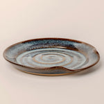 Ceramic plate with concentric circle design on a beige background