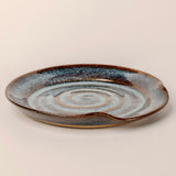 Ceramic plate with concentric circle design on a beige background