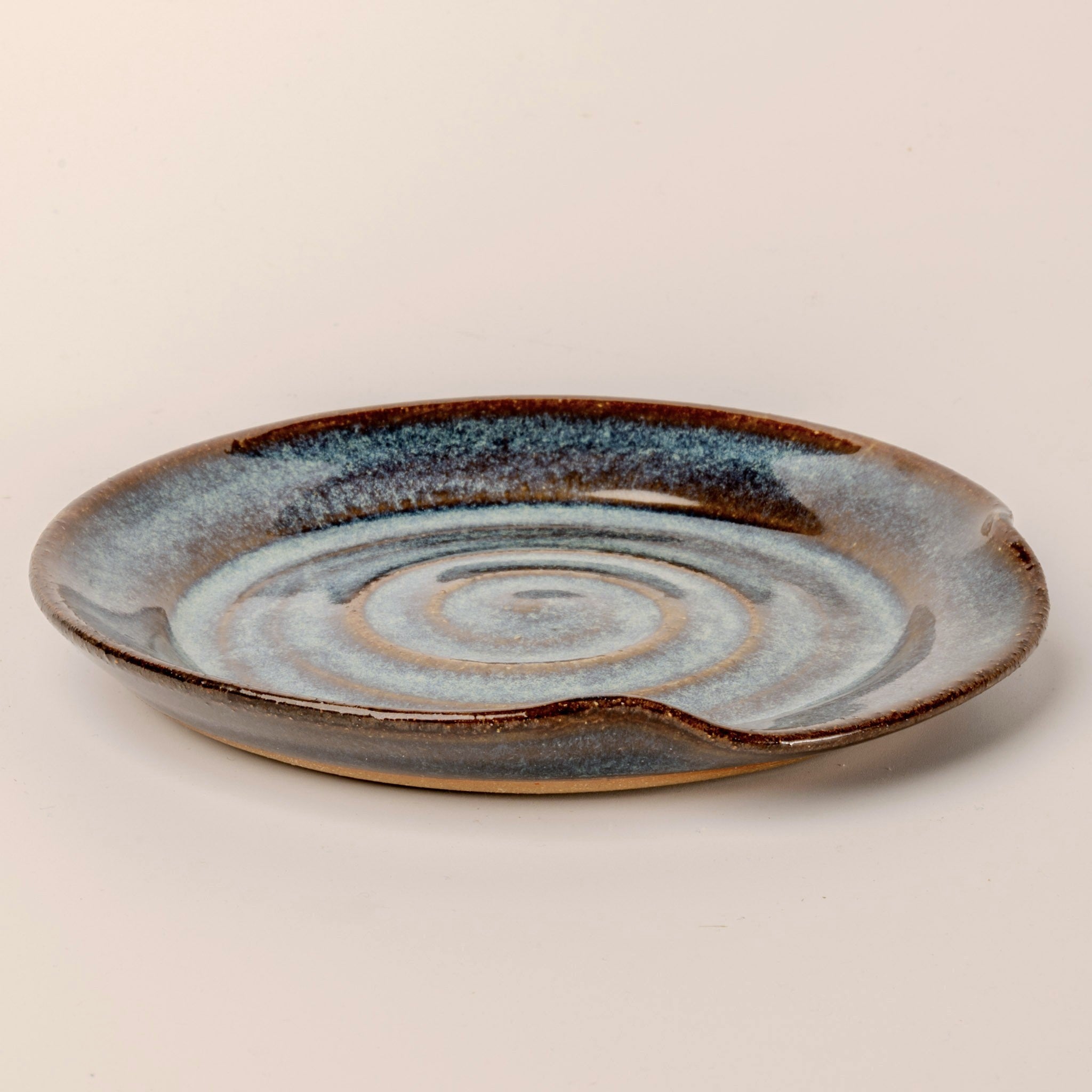 Ceramic plate with concentric circle design on a beige background