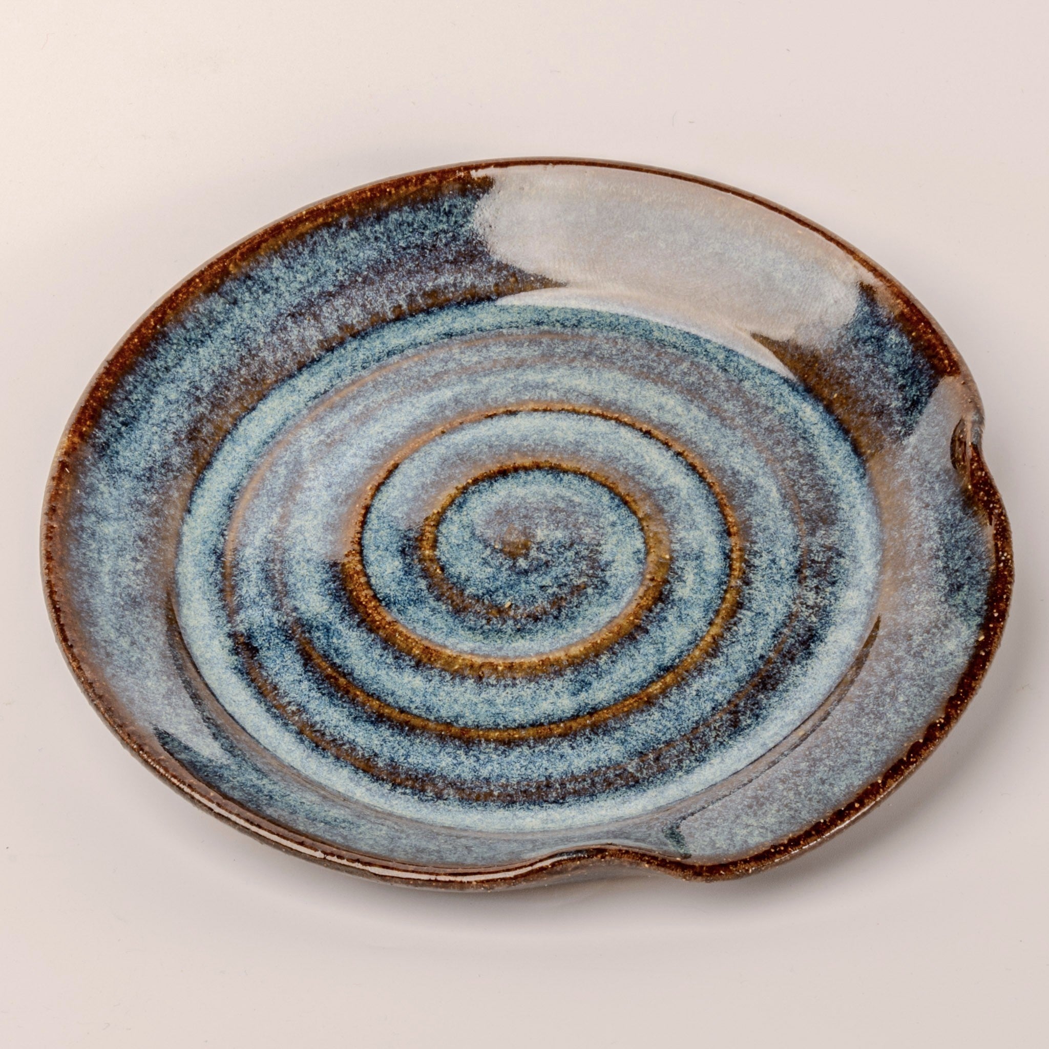 Ceramic plate with spiral design on a beige background